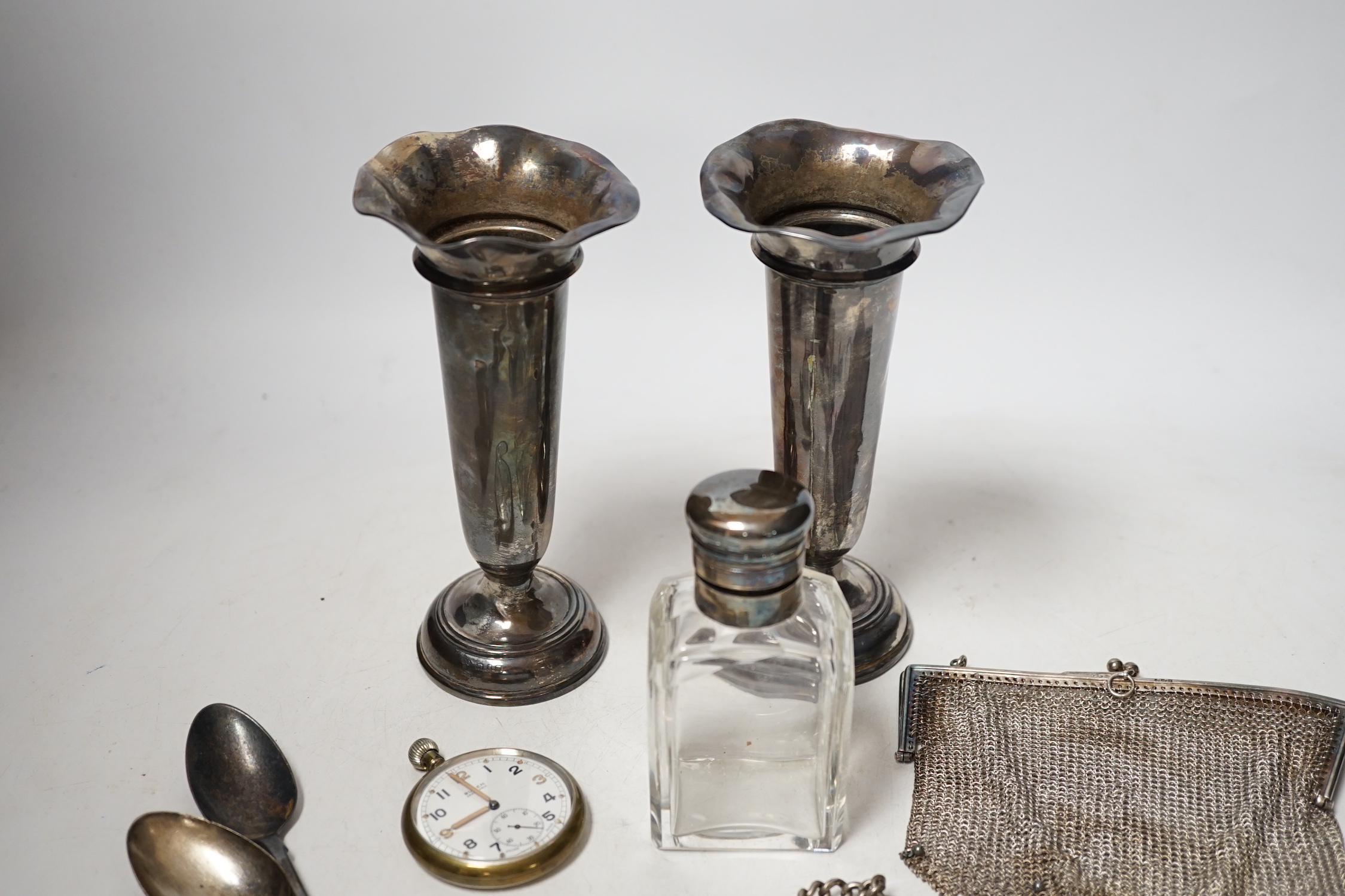 A matched pair of George V silver mounted posy vases, 16.3cm, together with a silver topped toilet jar, silver vesta case on a silver albert, a silver mesh evening bag, two silver spoons and a base metal pocket watch.